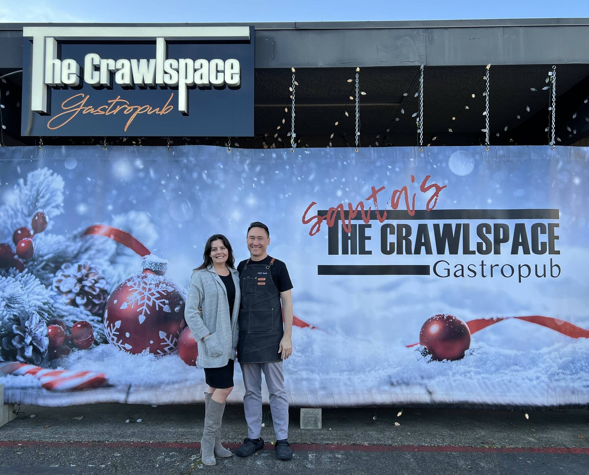 The Crawlspace Gastropub owners Robin and Jason Farrish stand in front of their restaurant, which is currently decorated for the holidays. Photo courtesy of Soyun Chow